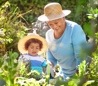 Woman gardening outdoors with a child