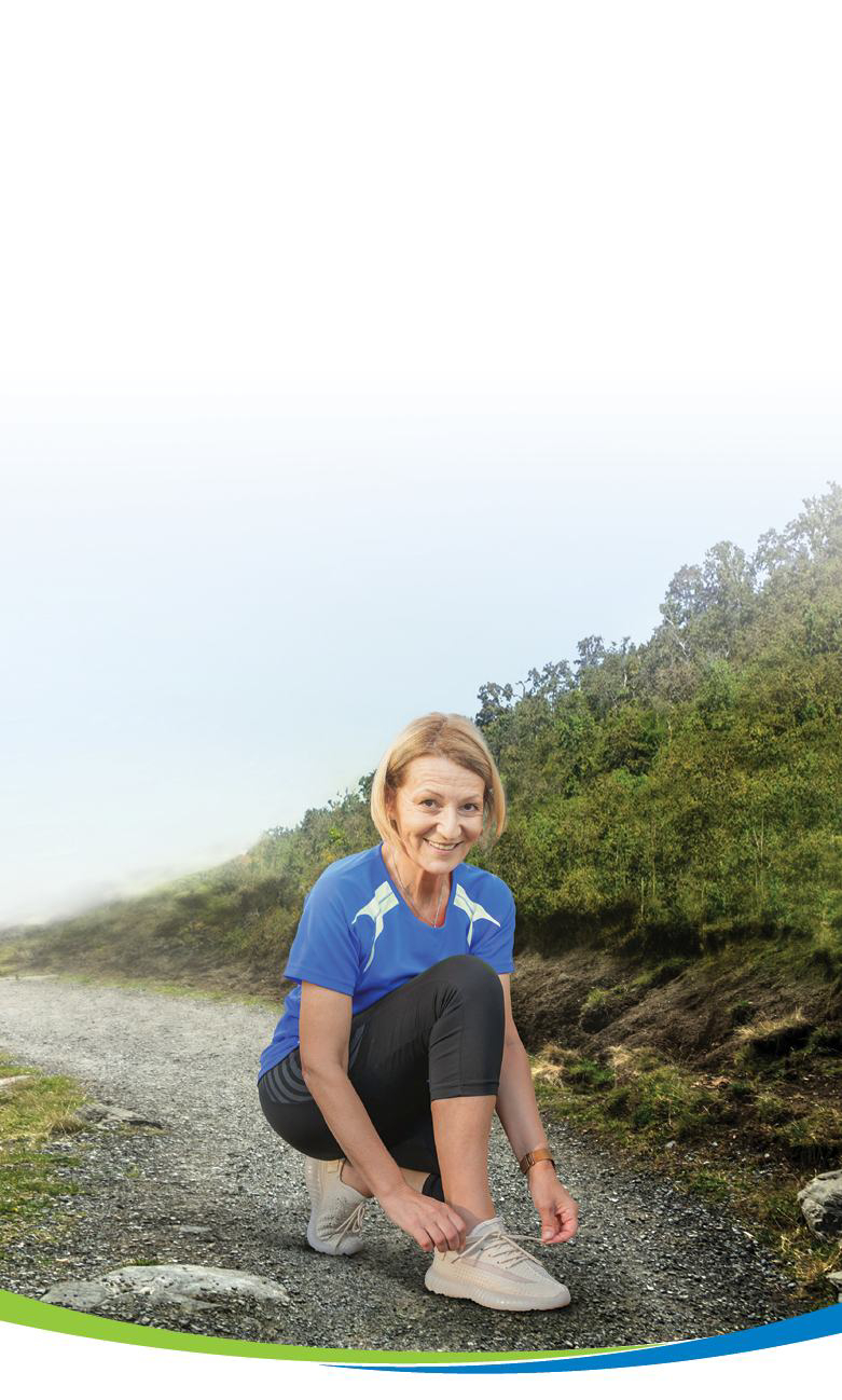 Woman in athletic clothing stretching outdoors on a trail